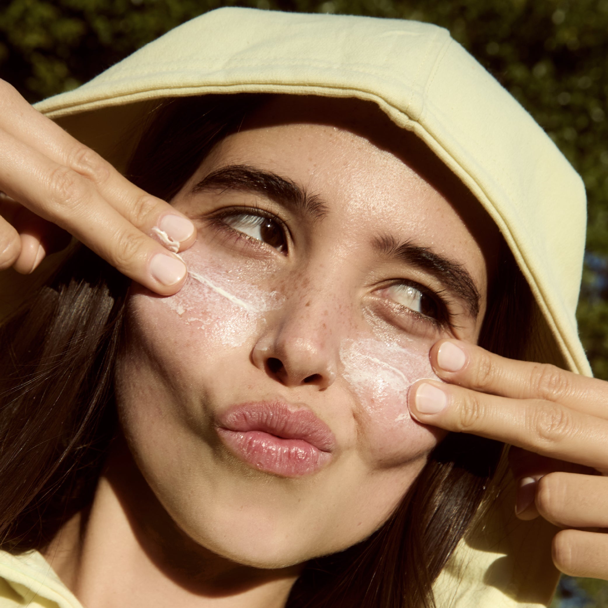 Person applying Sunny Side Up sunscreen to their face outdoors