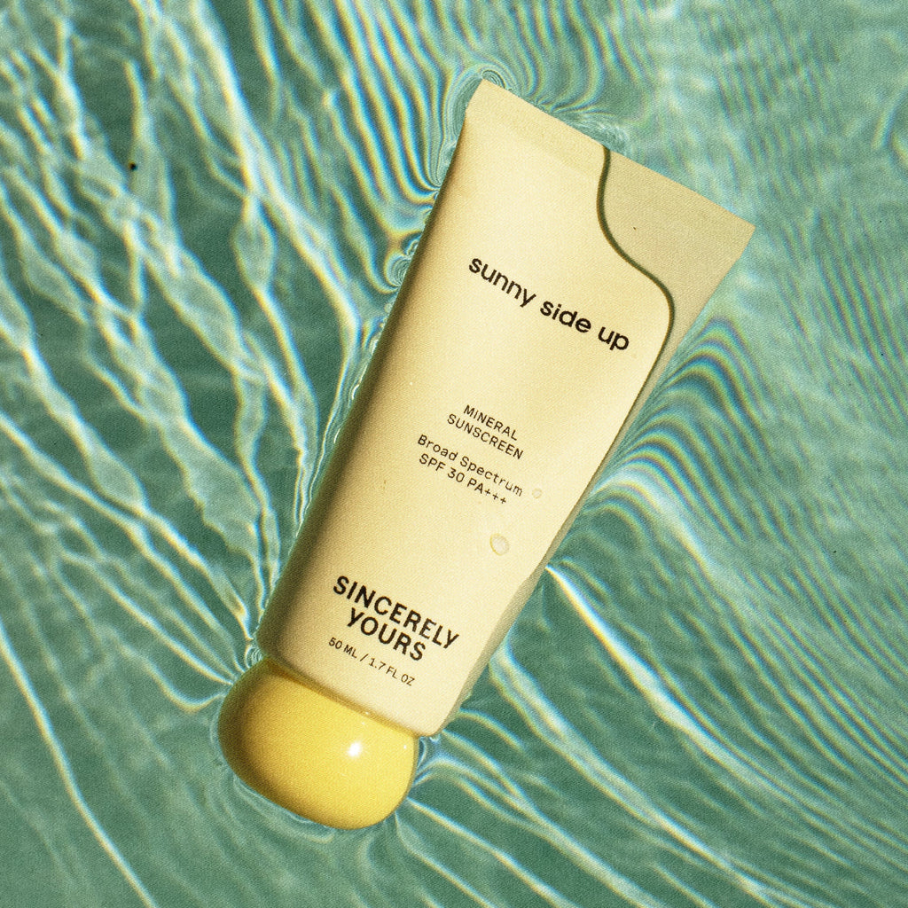 Sunscreen bottle labeled 'sunny side up' on a water surface